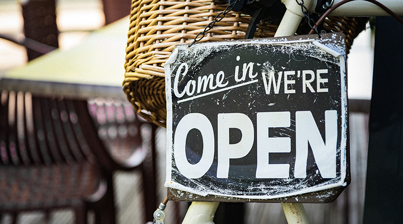Image of a 'Come In We're Open' sign on a bicycle